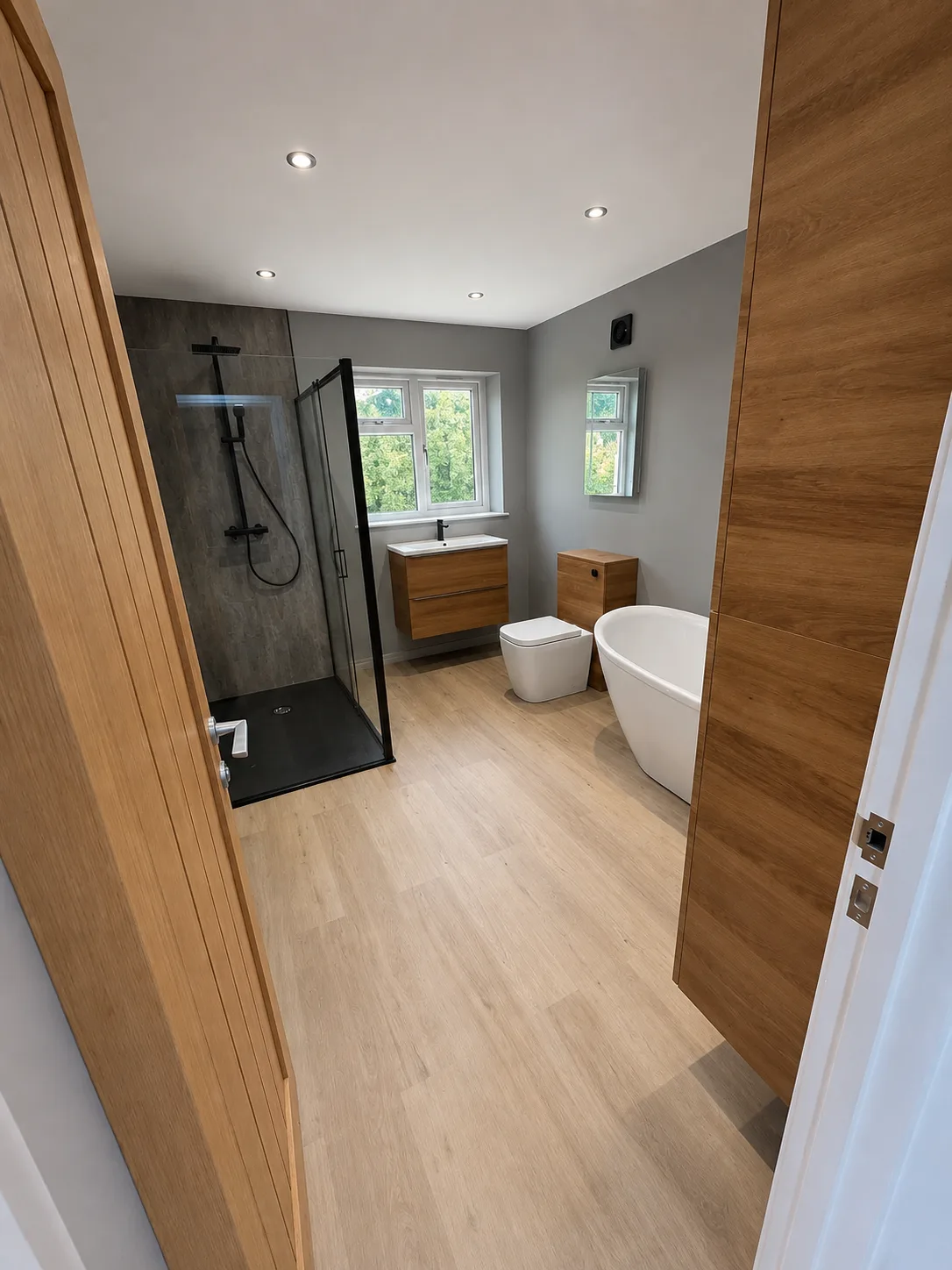 Second bathroom — walk-in shower in a slate-tile cubicle alongside a freestanding tub.