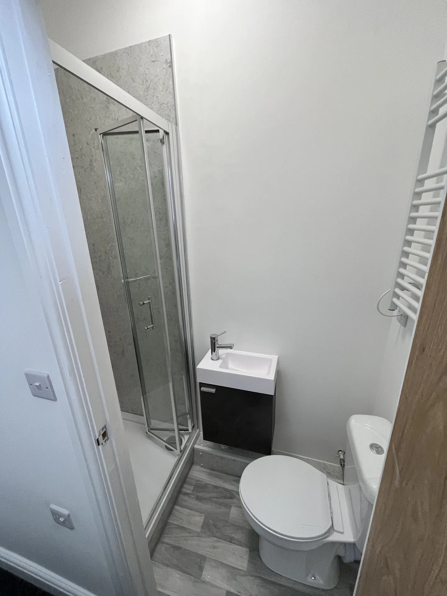 Ensuite bathroom — quadrant shower, vanity unit and heated towel rail.