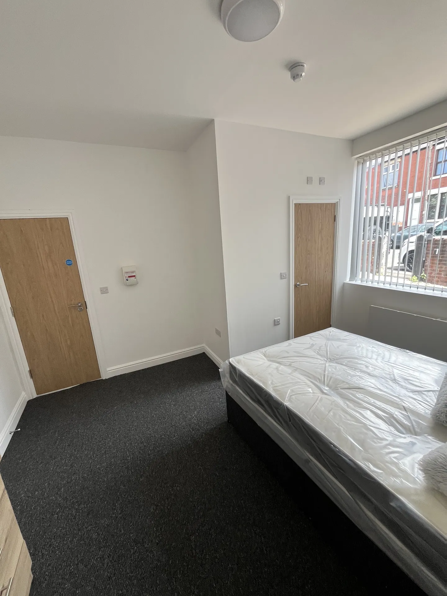Ensuite bedroom — fresh carpet, oak dresser and large window throwing natural light into the room.