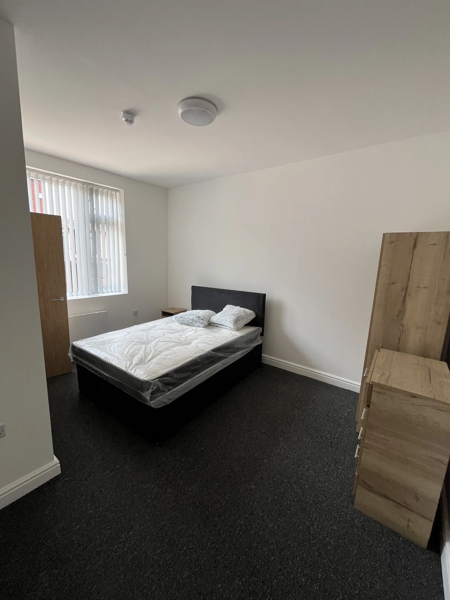 Ensuite bedroom — wide layout with wardrobe and dresser, ready for tenant arrival.