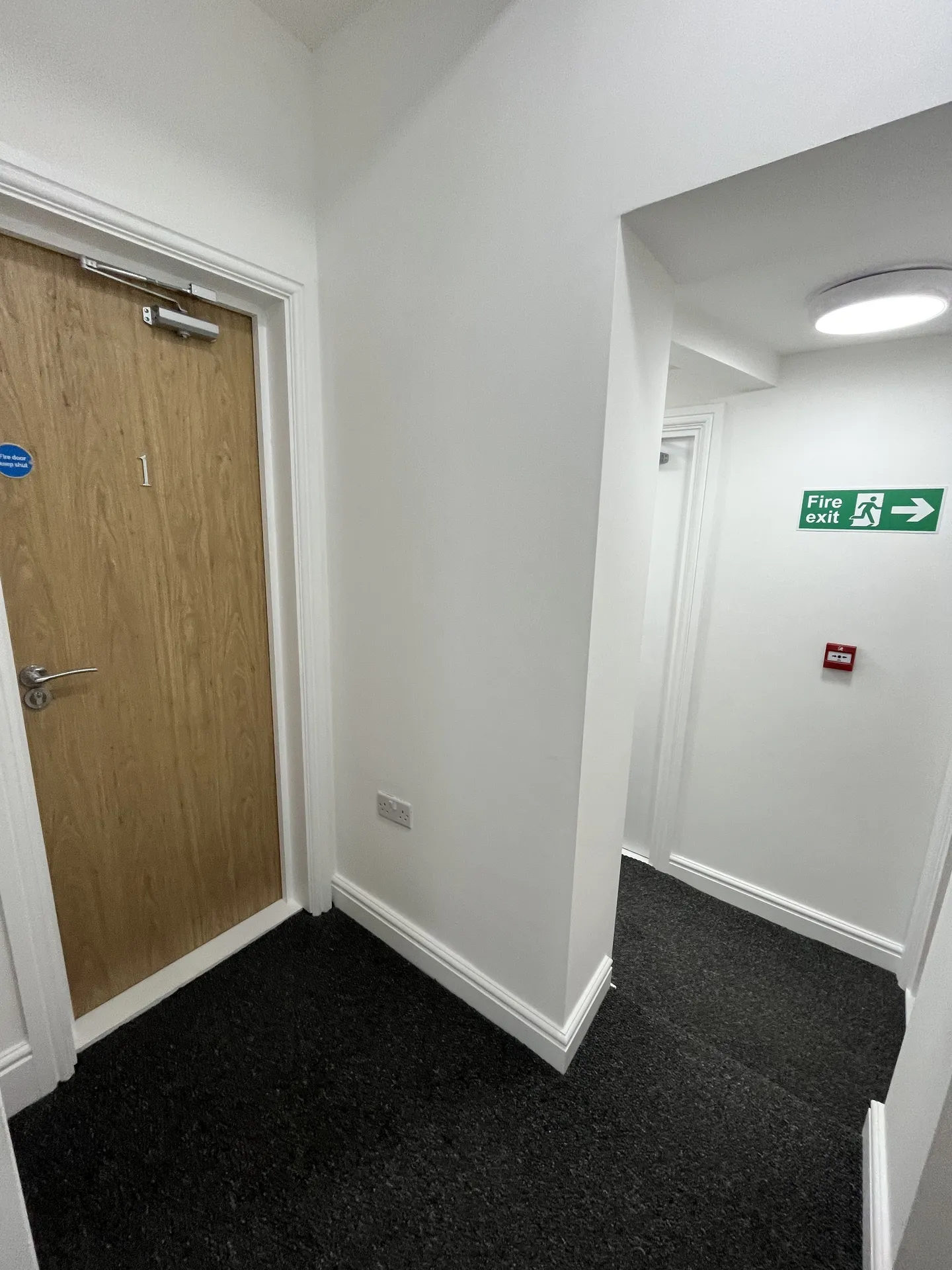 Corridor — fire-door spec and fire-exit signage to the supported-living standard.